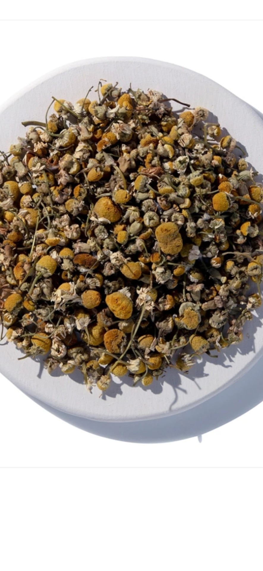Dried chamomile flowers in a white bowl