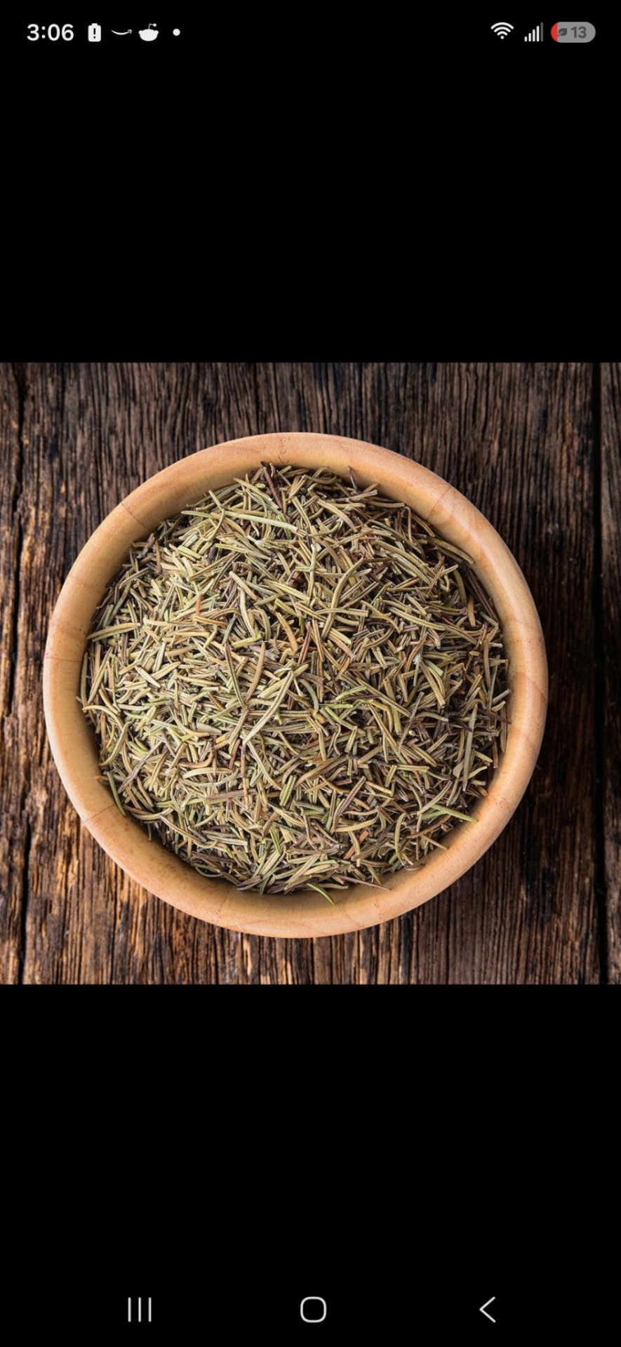 Dried rosemary needles in a wooden bowl