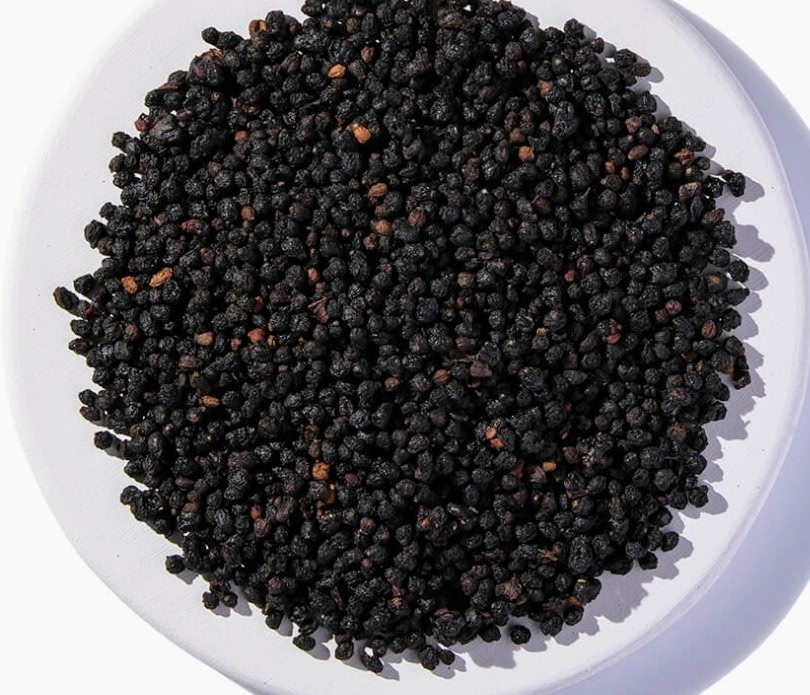 Dried elderberries in a white bowl